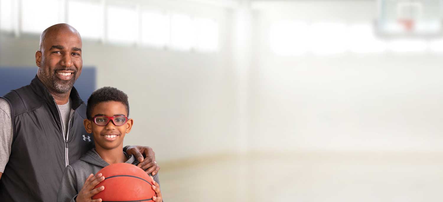 Father embracing son holding basketball